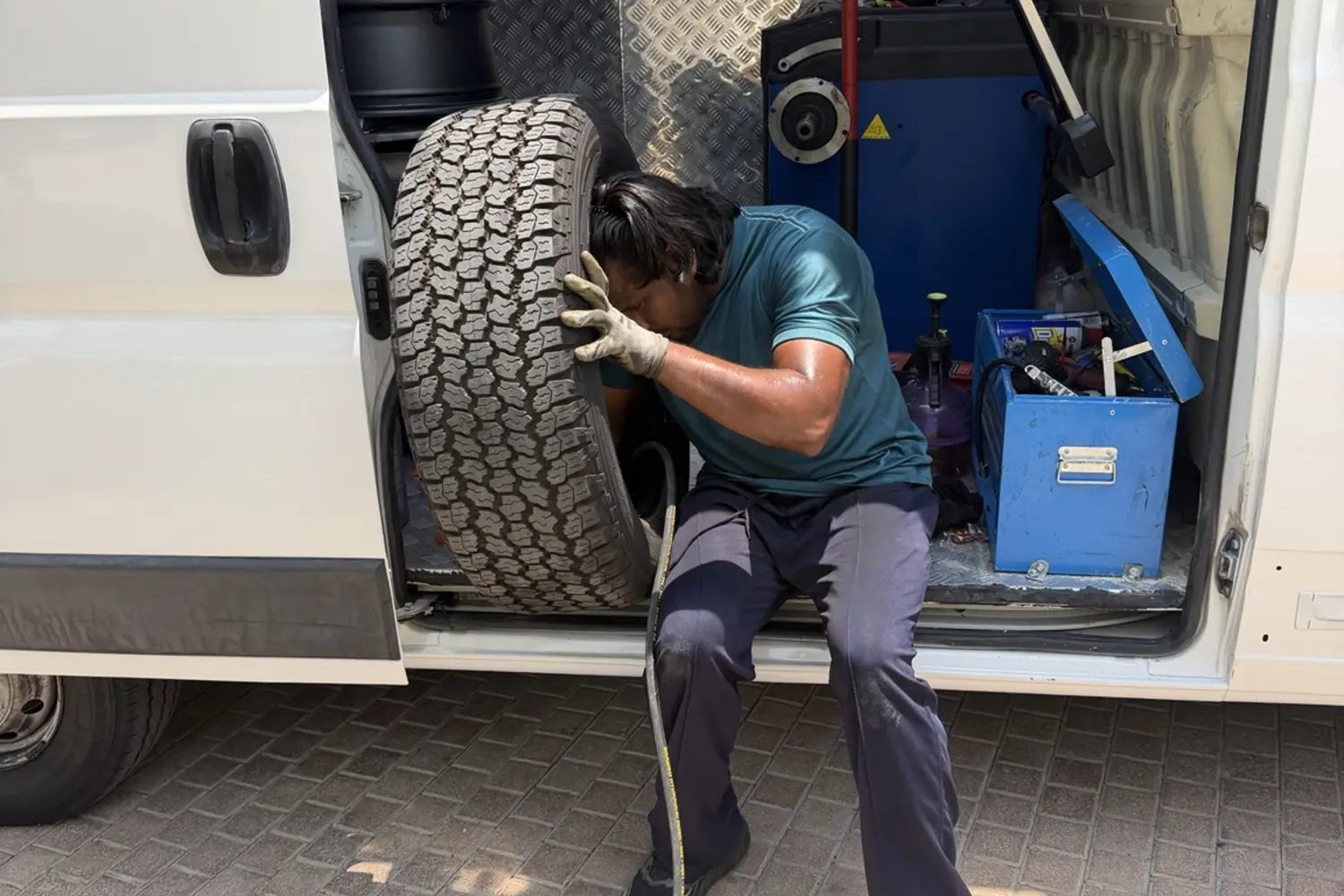 Mobile tyre technician working beside an equipped service van