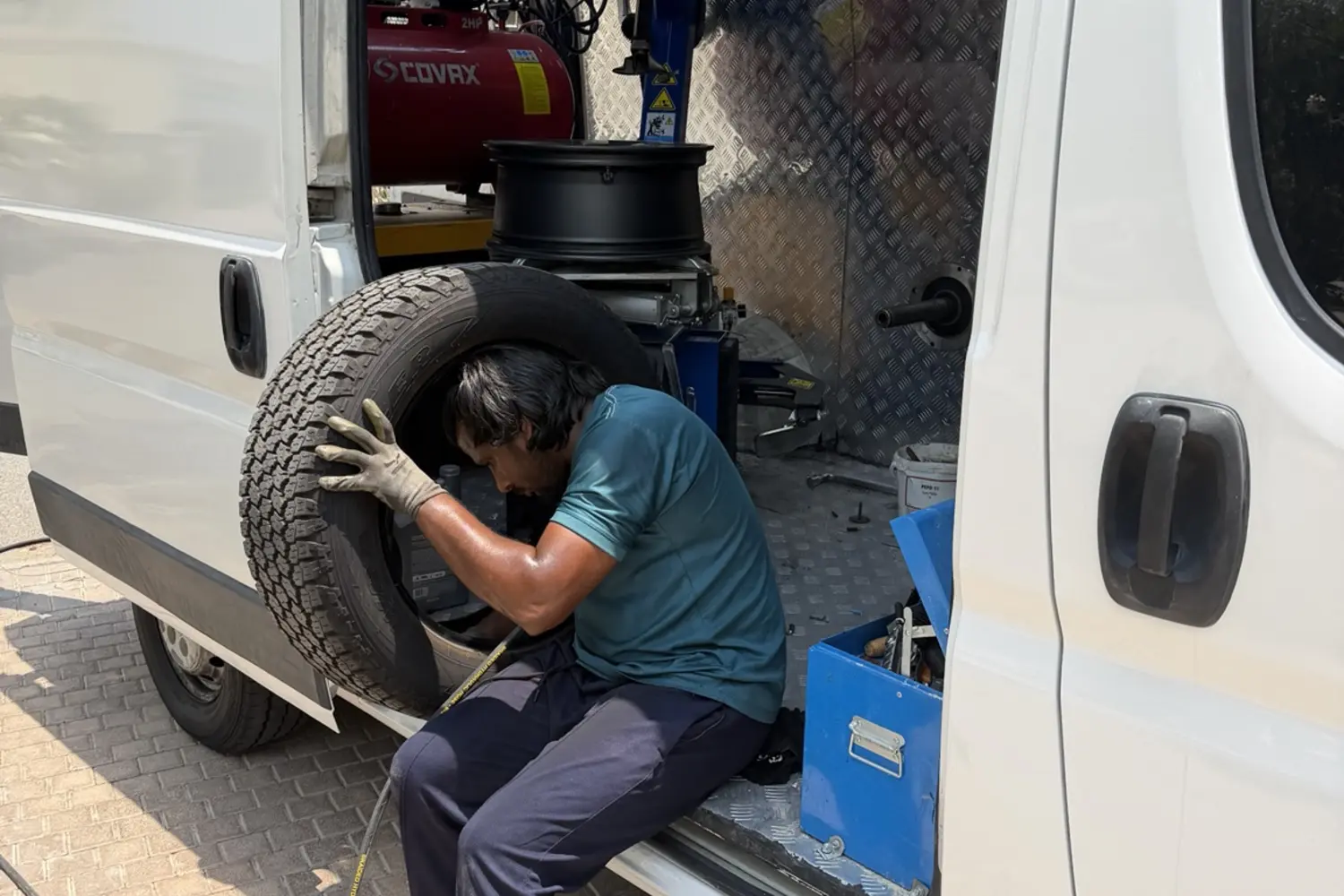 Mobile tyre technician fitting a tyre with professional equipment